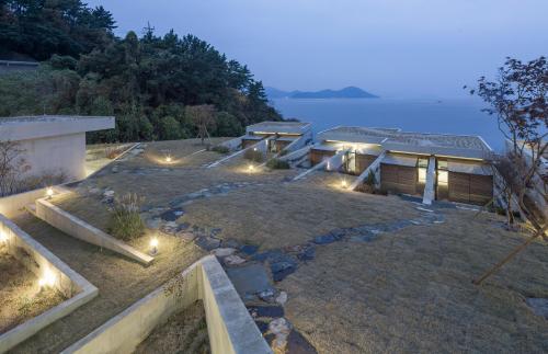 Mountain villa built next to coastal road, half of surface of building is recessed into ground, heat preservation and insulation
